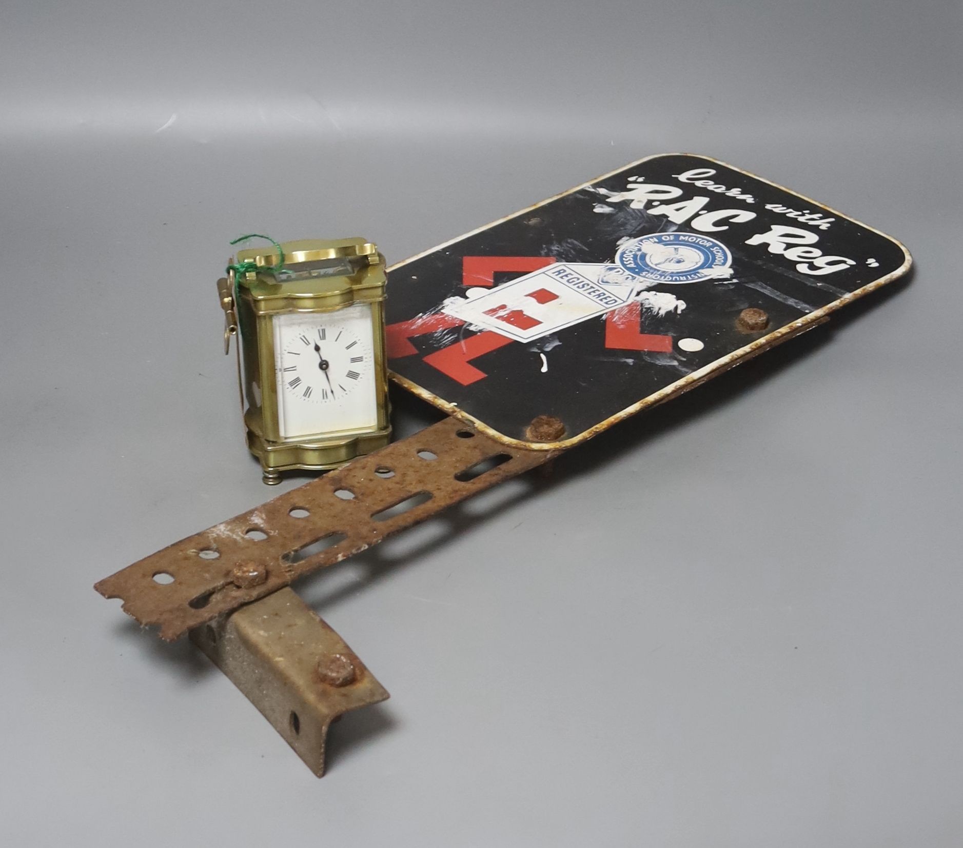 An RAC Reg advertising enamel sign and a brass cased carriage timepiece